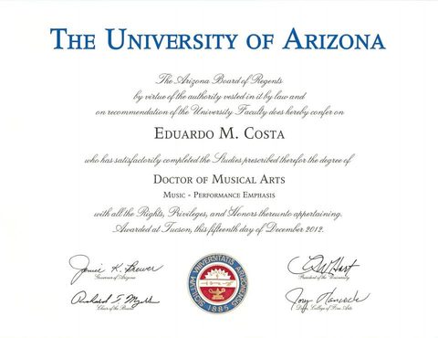 Dr. Costa holding a guitar in a recital hall